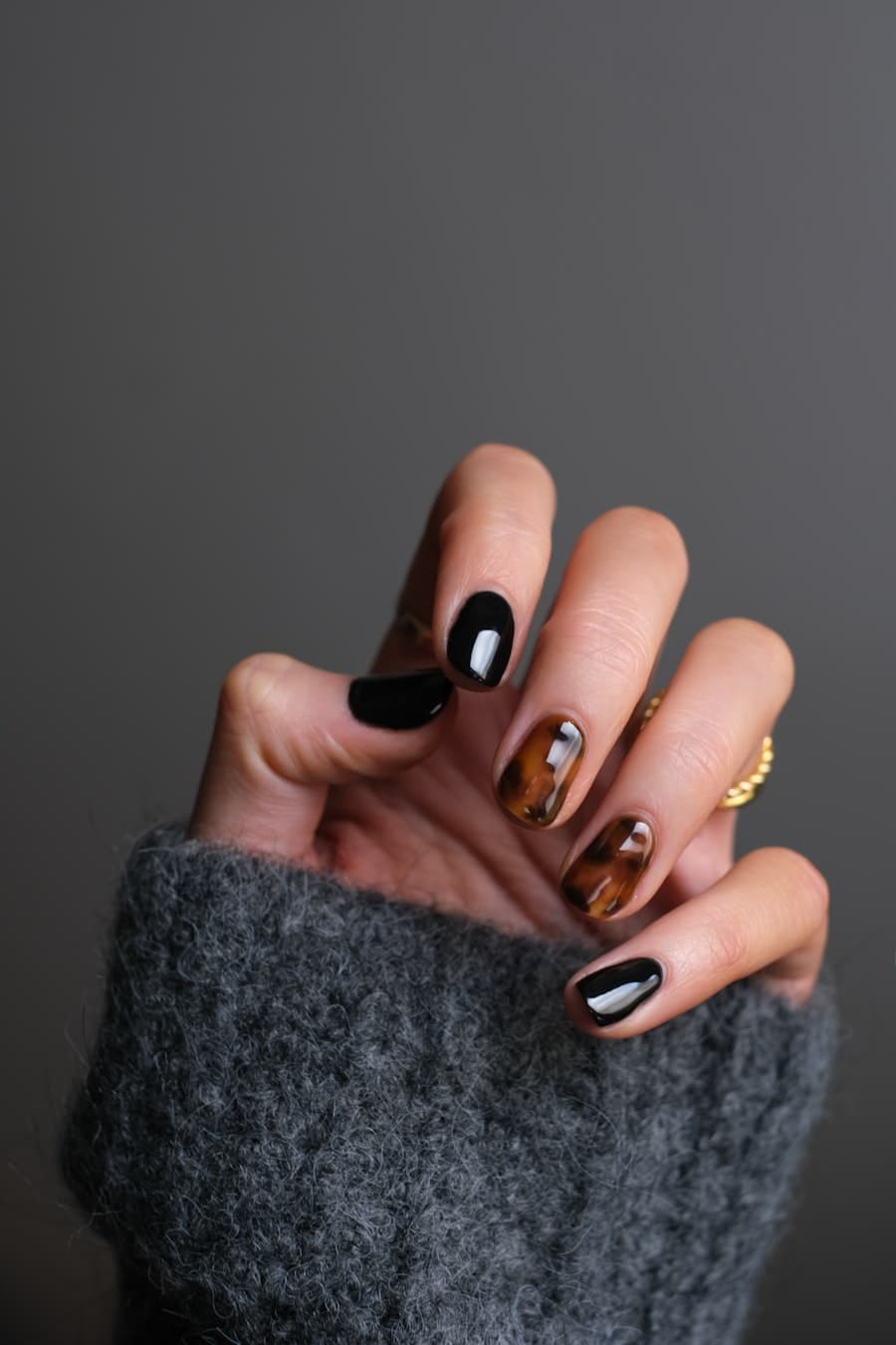 Detalhe de unhas com esmaltes em tons quentes