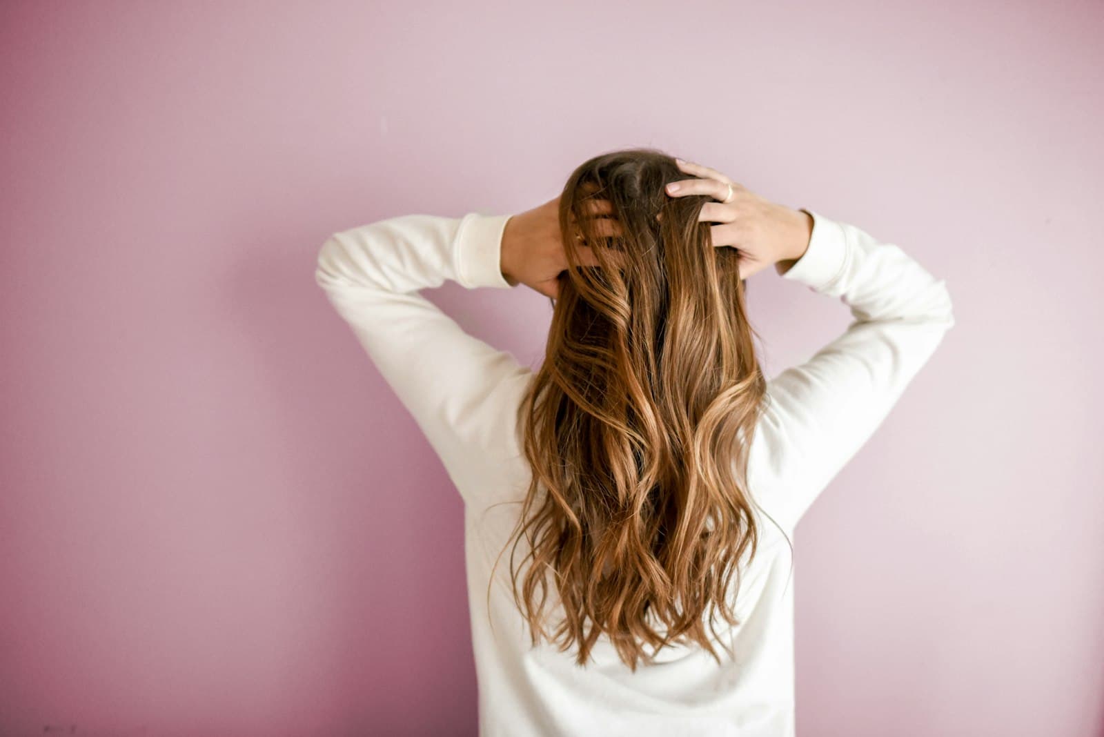 Cliente cuidando do cabelo, fundo rosa pastel